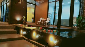 A modern indoor space with a coffee shop, a water feature, and seating area. - The Terrace Khlongtoei (Hat Yai)