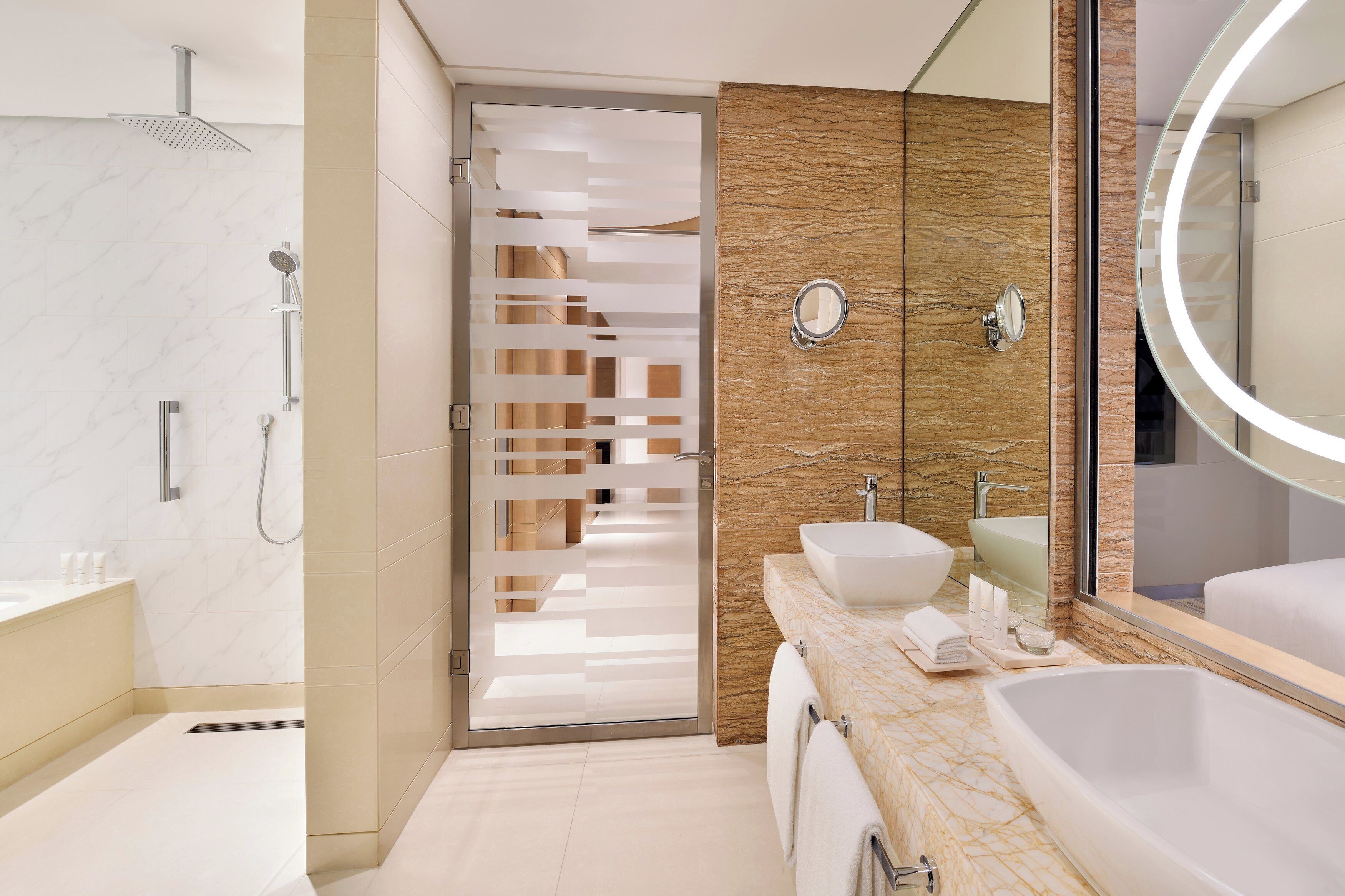 Ein modernes Badezimmer mit bodenebenen Dusche, großem Spiegel und Marmorplatte.