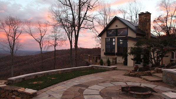 Set against a mountainous backdrop, this house offers a cozy retreat with a stone fireplace and patio with fire pit.
