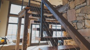 Eine Holztreppe mit einer Steinmauer an einer Seite und einem großen Fenster an der anderen.
