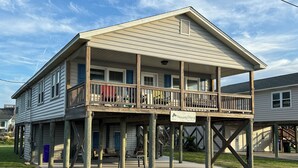 Een houten huis met twee verdiepingen, een balkon, een veranda en een bord met de tekst 'Heavenly Days III'.