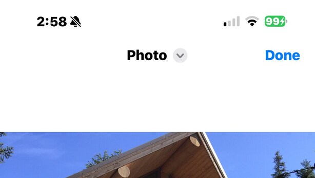A log cabin with a balcony, wooden chairs, and a stone wall. - Girdwood Alaska rental near ski resort. Customers rave: so cute, clean and cozy! (Anchorage)