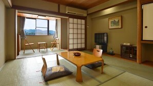 A traditional Japanese room with tatami flooring, a low table, and sliding doors. - Hotel Suimeikan (Yamanouchi)