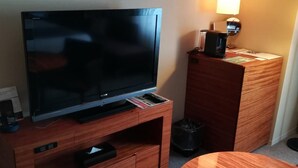 A hotel room with a flat-screen TV on a wooden stand, a coffee machine, and a small table. - Hotel Metropolitan Akita (Akita)