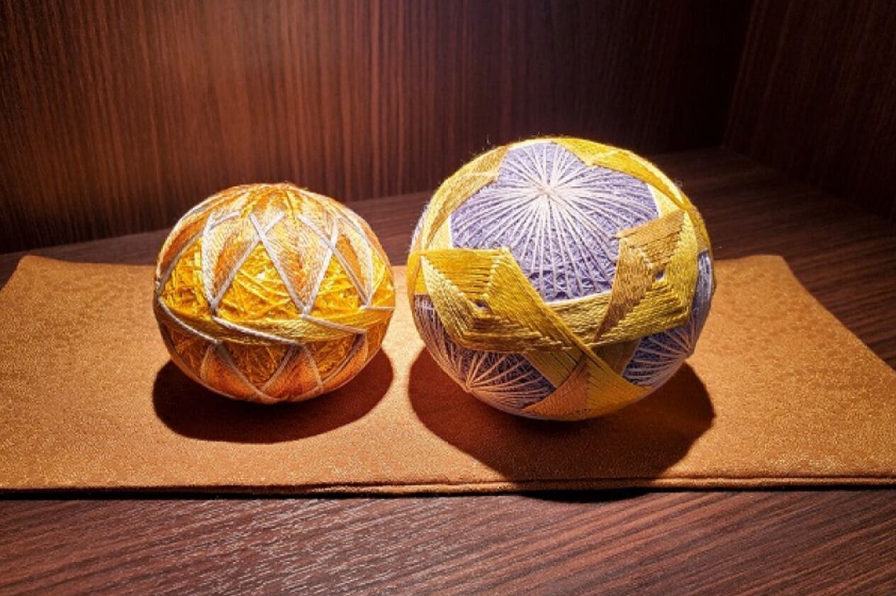 Two spherical objects with woven patterns on a brown surface.