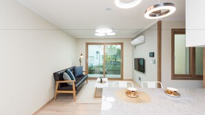 Una sala de estar moderna con un sofá, una mesa de centro y un comedor con sillas y una mesa.