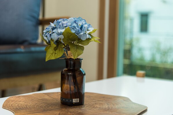 A brown vase with blue flowers on a wooden table.