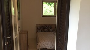Une chambre à coucher avec un lit, une fenêtre et une porte.