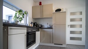Een keuken met een kookplaat, oven, magnetron en kastjes.