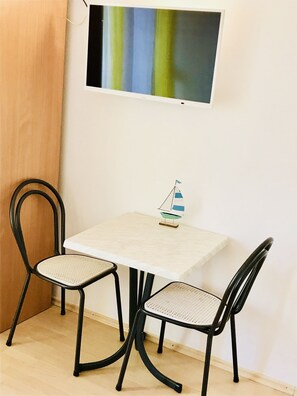 Intimate dining area with a table and two chairs, featuring a decorative sailboat model.