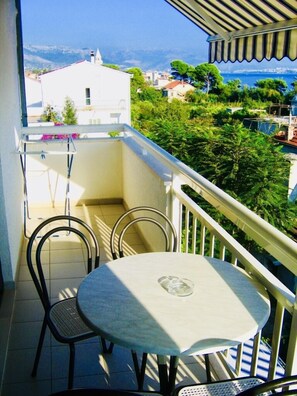 Enjoy a peaceful moment on this balcony with a scenic view of the coastal town.