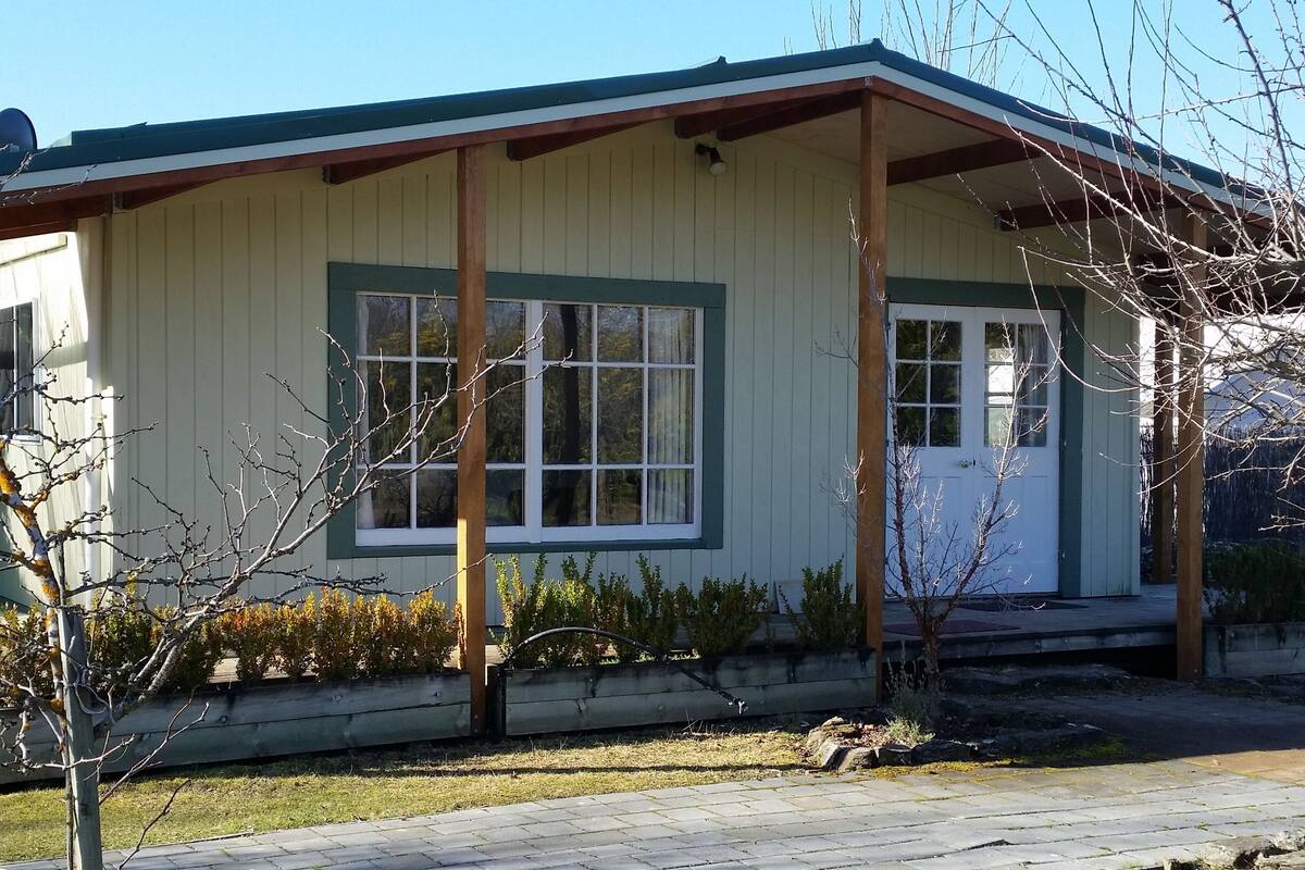 A single-story building with a flat roof, a covered porch, and a front door.
