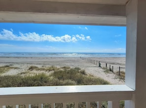 A beach view from a balcony with a wooden fence and a clear sky. - Front Row Beach Home, Your Piece of Paradise (Galveston)