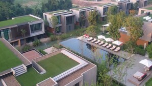 A modern resort with multiple buildings, a swimming pool, and outdoor seating areas. - Sandao Condo Khaoyai (Pak Chong)