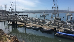 A marina with various boats docked, a wooden pier, and a clear sky. - Harbor House in Morro Bay  (Morro Bay)