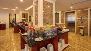 A buffet area with a marble column, stainless steel appliances, and a variety of food items. - Red Sun Nha Trang Hotel (Nha Trang)