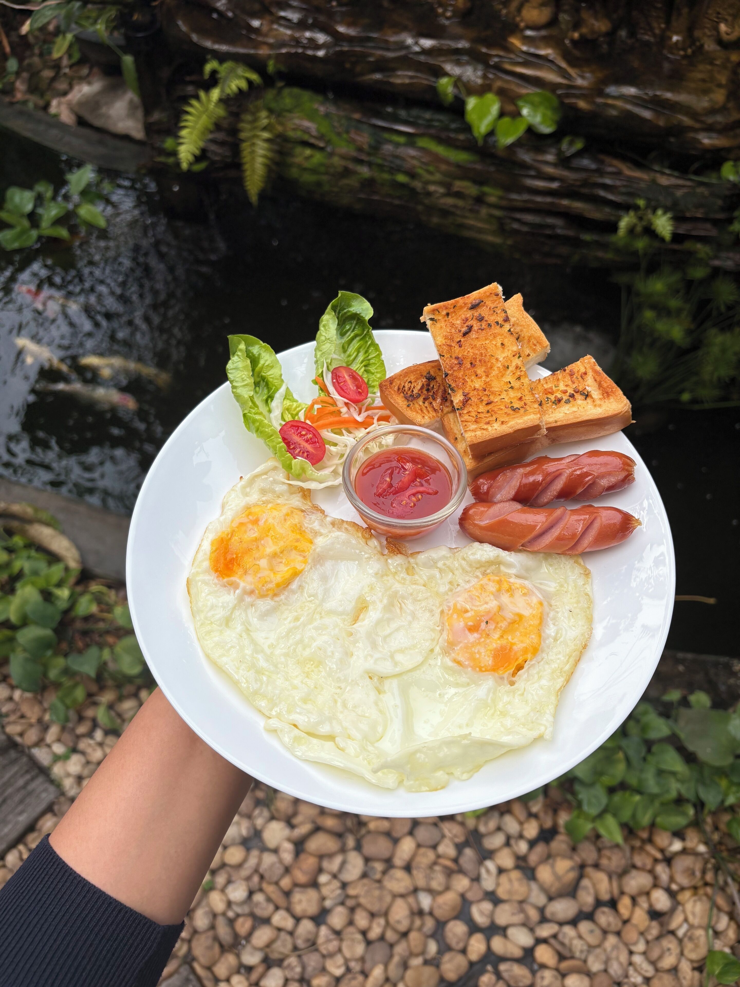 A plate of food with eggs, sausage, toast, and salad.