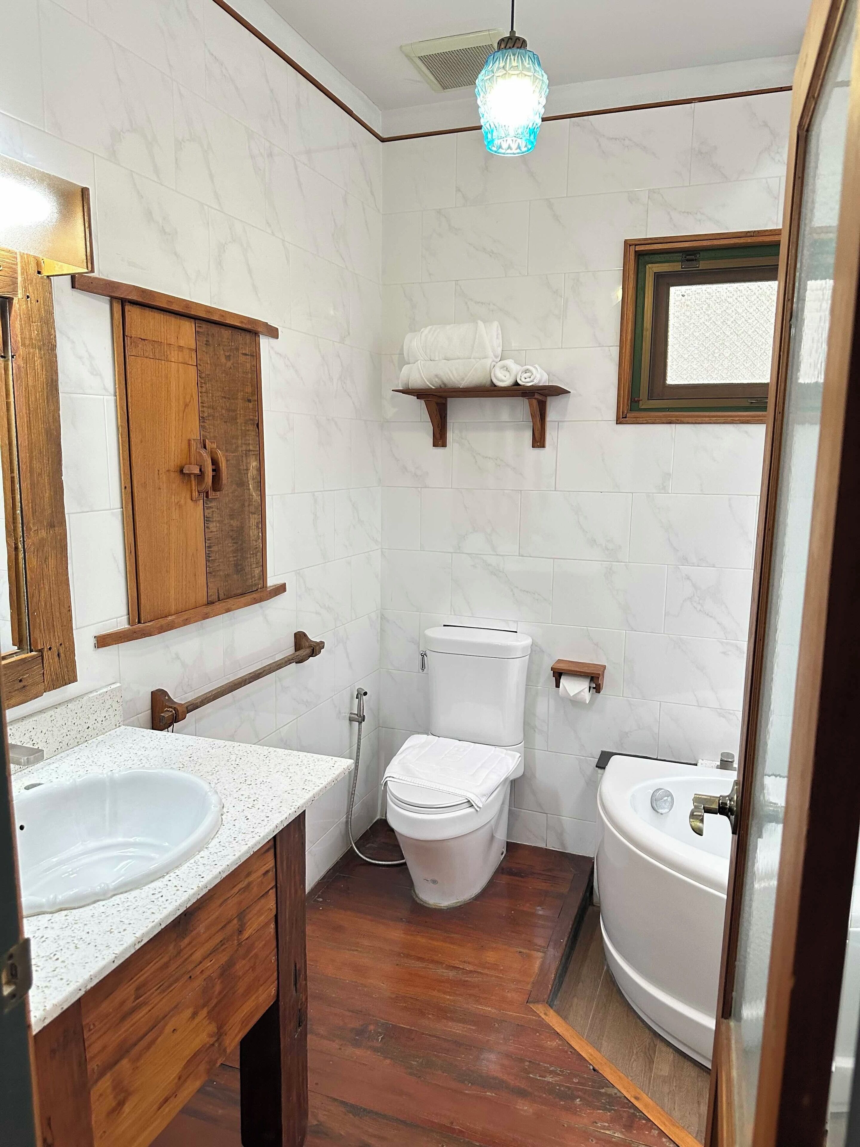 Ein Badezimmer mit einem Holzkosmetikschrank, einer Toilette und einer Badewanne.