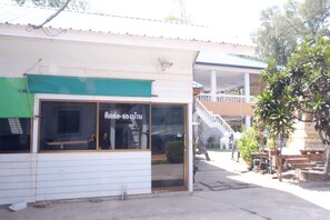 Un edificio con toldo verde y un gran ventanal.