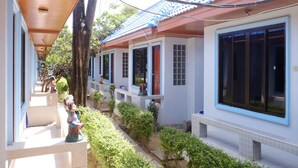 A row of traditional-style buildings with large windows and a covered walkway. - Chayta Resort (Rayong)