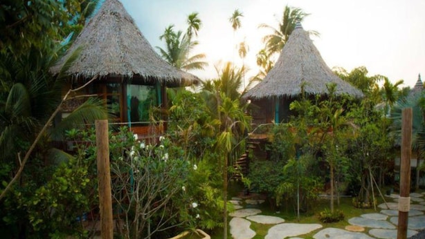A tropical resort with thatched-roof huts and a stone pathway. - Amphawa Club (Amphawa)