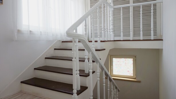 A staircase with white balusters and dark wooden steps.