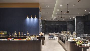 Buffet modern amb diverses estacions de menjar i zones de seients.
