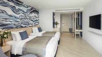 A modern hotel room with a large bed, a desk, and a TV.