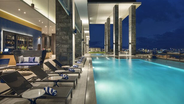 Un espace aménagé au bord de la piscine, avec des chaises longues et un bar.
