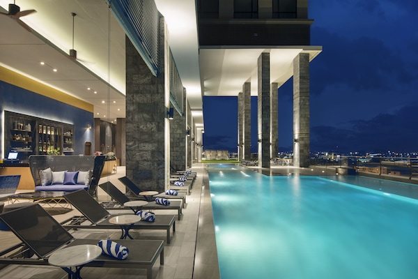 Una piscina al aire libre, sillones reclinables de piscina