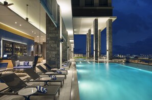 Un espace aménagé au bord de la piscine, avec des chaises longues et un bar.