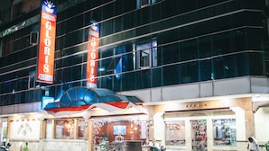 Un hotel con un llamativo letrero que dice 'HOTEL GLORIS', un gran cartel y una fachada clásica con un letrero que dice 'GLORIA'.