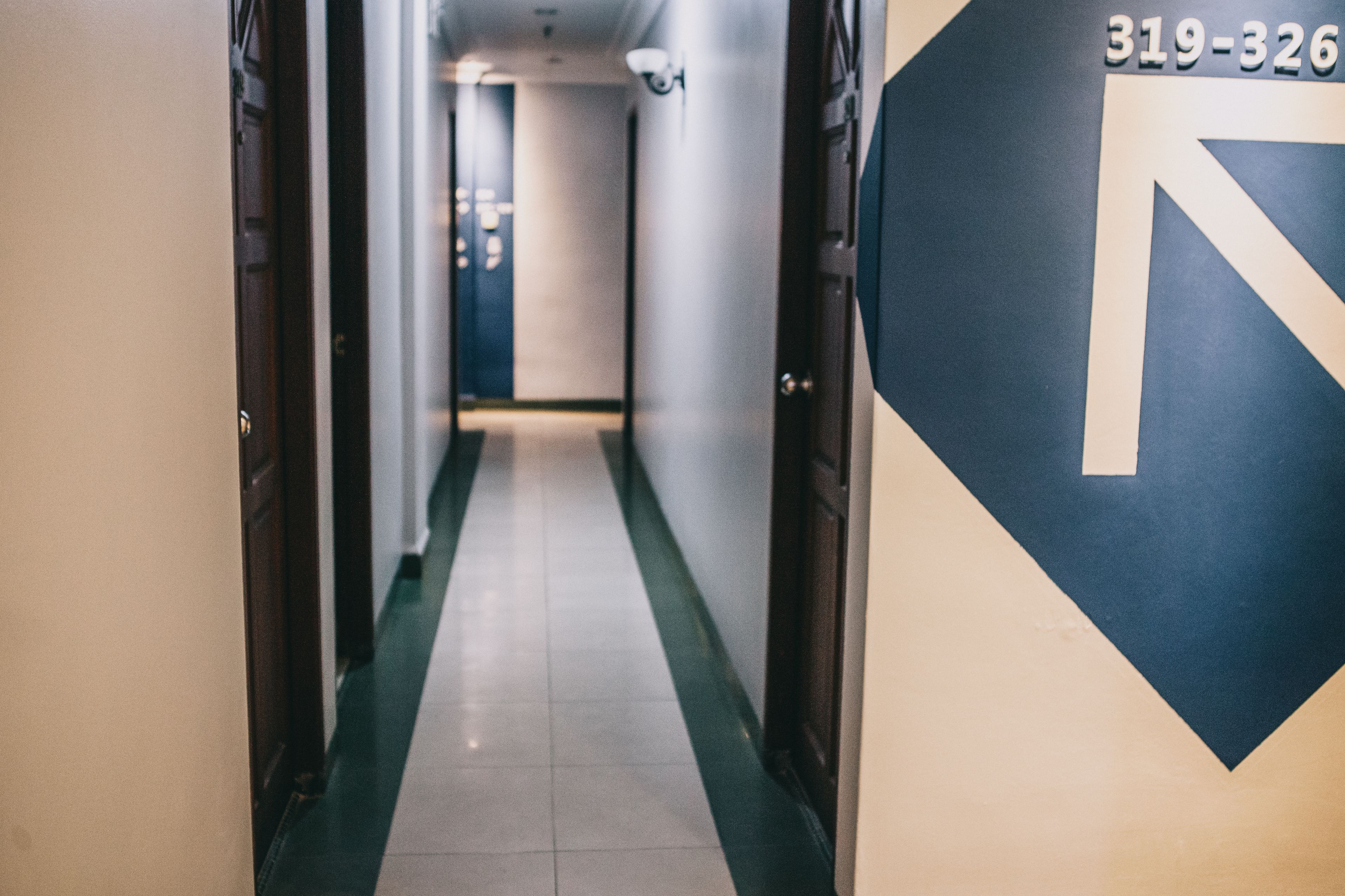 Un pasillo de hotel con un cartel de indicaciones y un número de teléfono.