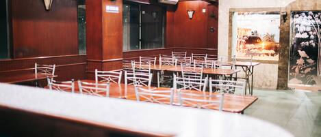 Un restaurante con paredes de madera, sillas blancas y mesas.