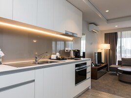 Una cocina de hotel moderna con horno empotrado, cafetera y lavabo.