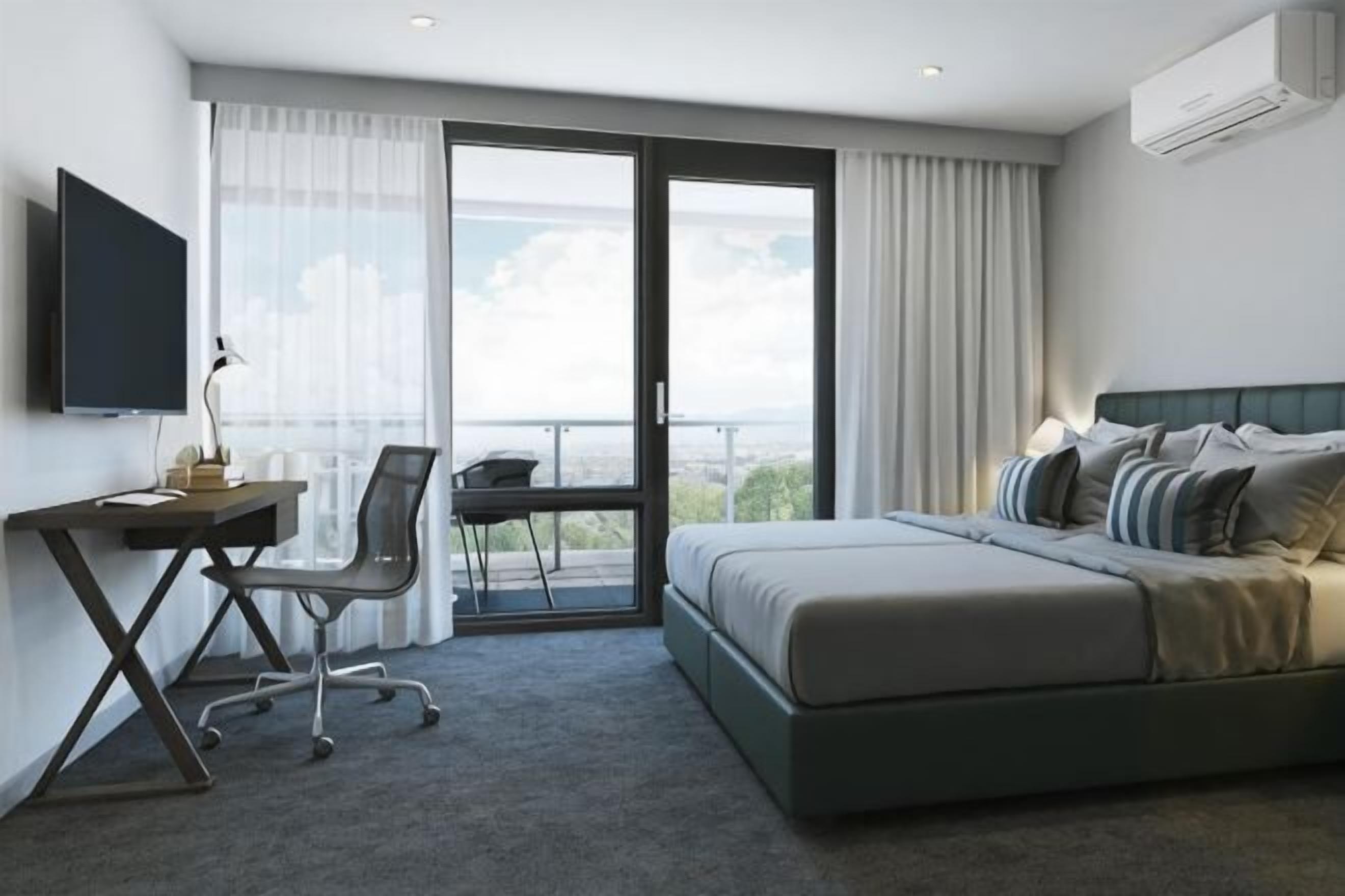 Une chambre d’hôtel équipée d’un lit, d’un bureau, d’une chaise et d’un téléviseur.