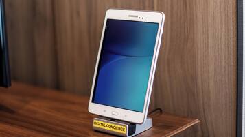 A white Samsung smartphone on a digital concierge stand.