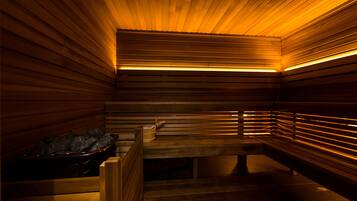 Eine Sauna mit Holzsitzen und einer Steinsinne.