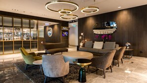 Un vestíbulo moderno con una zona de estar, un mostrador de recepción y una zona de bar.