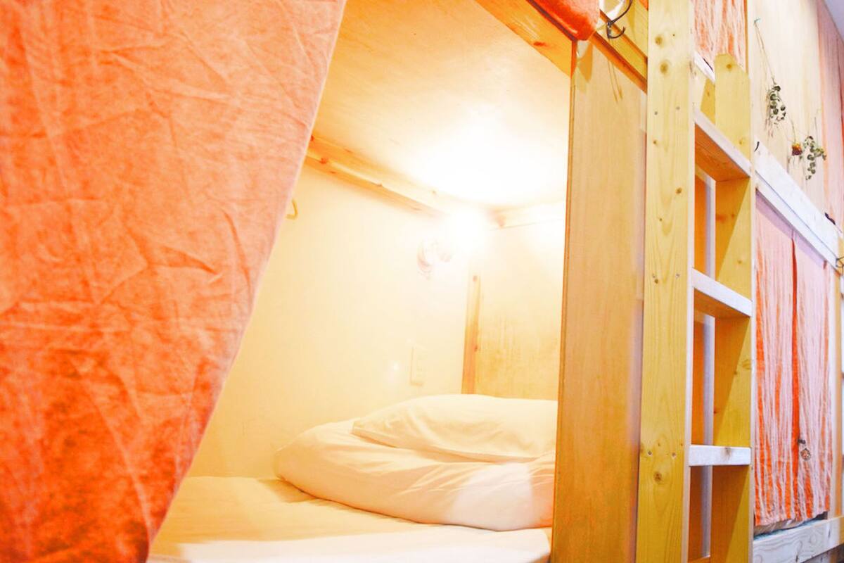 Una cama litera con estructura de madera y un colchón blanco.