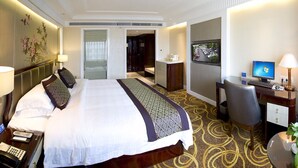 A hotel room with a large bed, a desk with a computer, a telephone, and a television. - HangZhou HuaYang Hotel (Hangzhou)