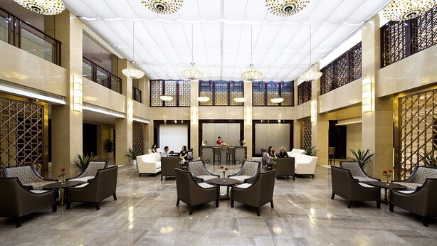 A spacious lobby with high ceilings, chandeliers, and a central seating area. - HangZhou HuaYang Hotel (Hangzhou)
