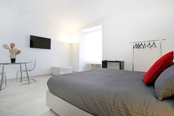 A modern bedroom with a bed, a flat-screen TV, a desk with chairs, and a window. - Houspitality Nero B&B (Rome)