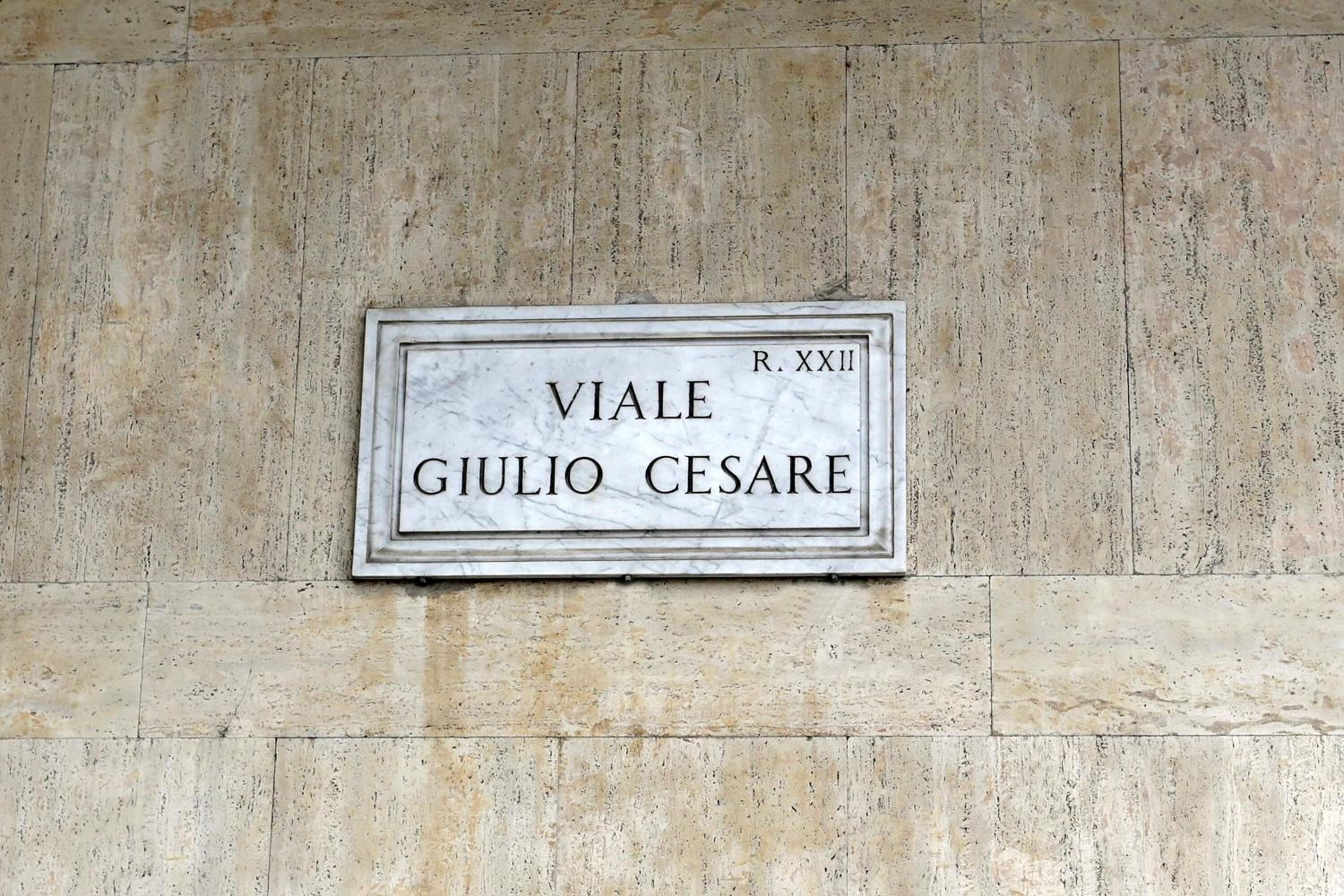 En marmorplade med indskriften "VIALE GIULIO CESARE R. XXII" monteret på en stenvæg.