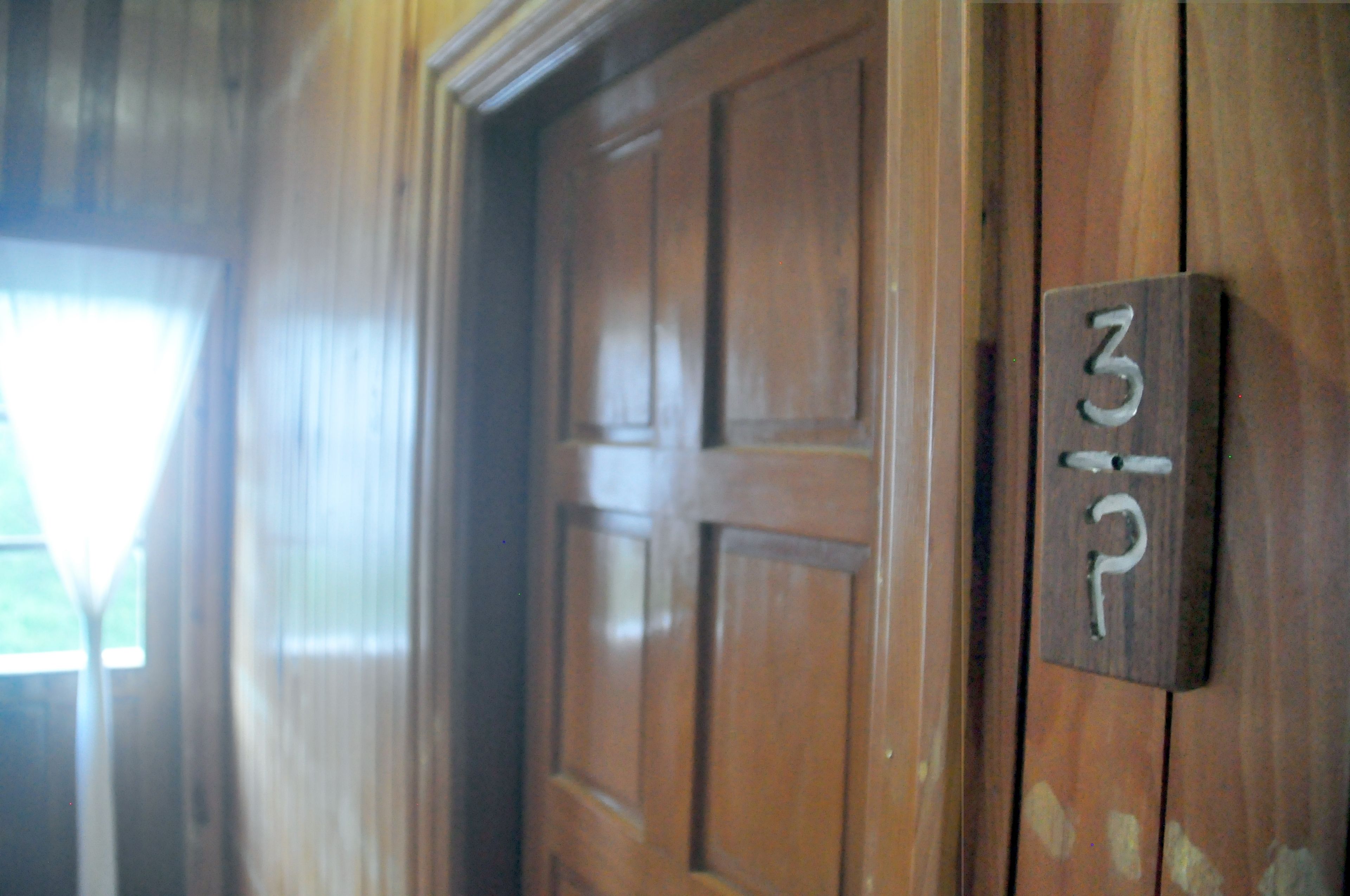 Una puerta de madera con una placa indicando la habitación 3P.
