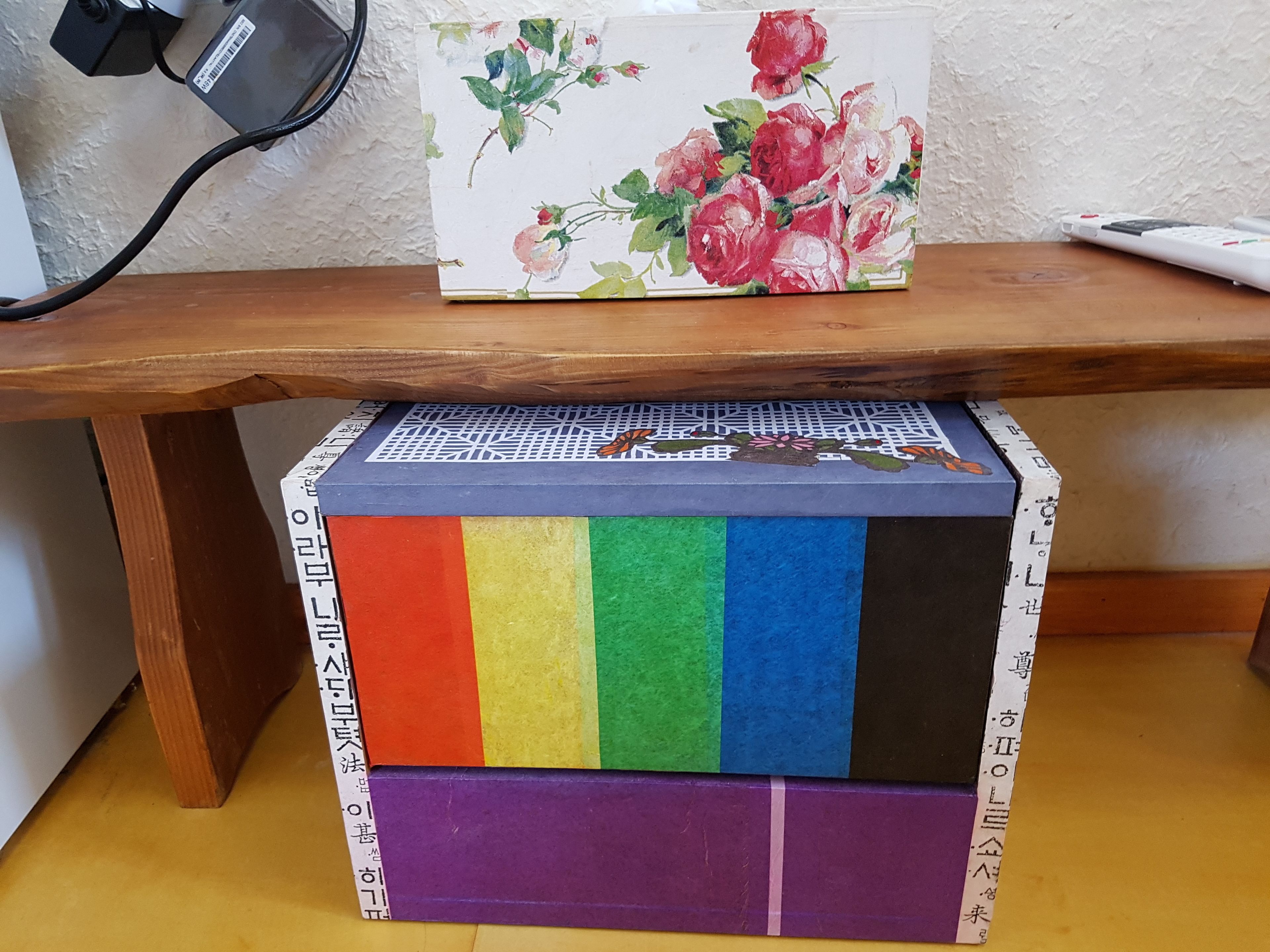 Una mesa de madera con una caja colorida y una tarjeta floral encima.