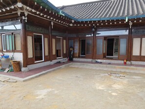 A traditional wooden building with a tiled roof and a covered courtyard. - The Hanok (Jeonju)