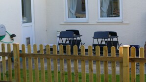 A wooden fence in front of a building with two windows and a door. - Magnolia B and B (Bristol)