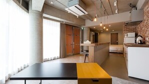 Une chambre d’hôtel moderne équipée d’un grand lit, d’un bureau et d’une kitchenette.