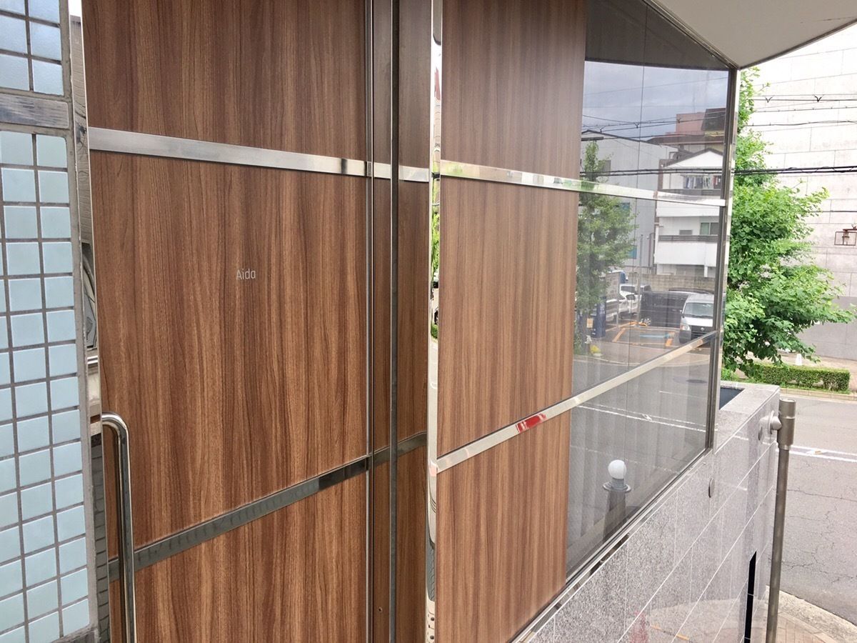 A wooden door with a metal handle and a glass panel.